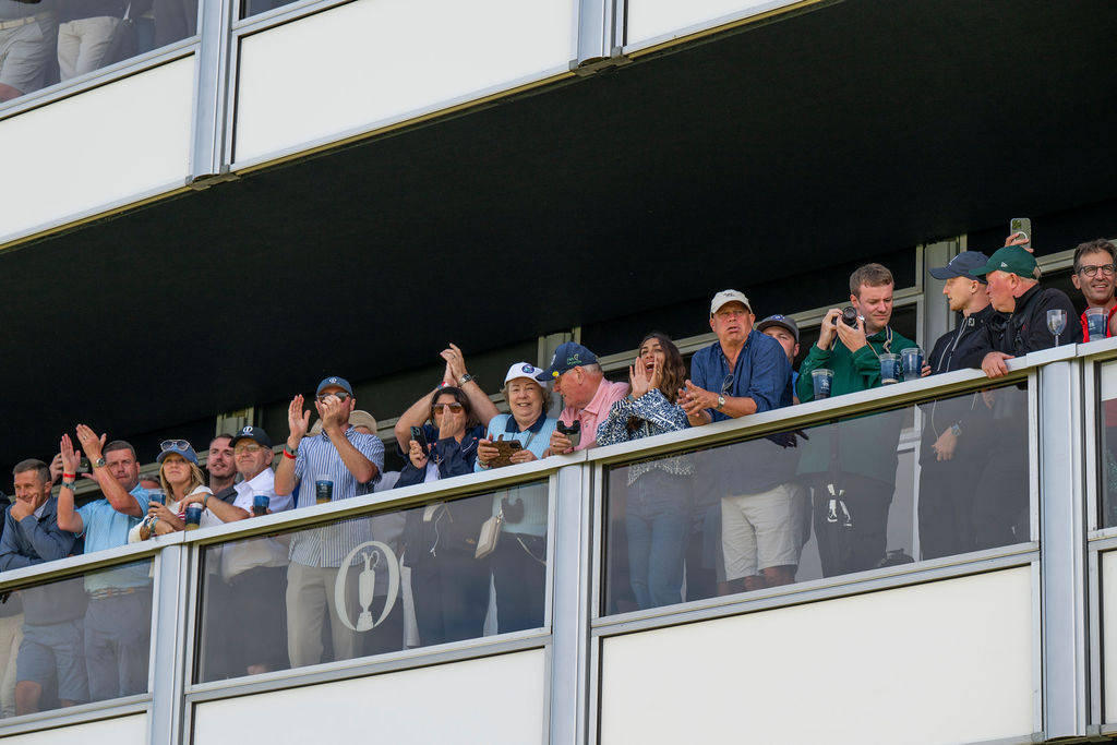 Fans watch the golf from a balcony at hospitality during The 153rd Open at Royal Portrush.